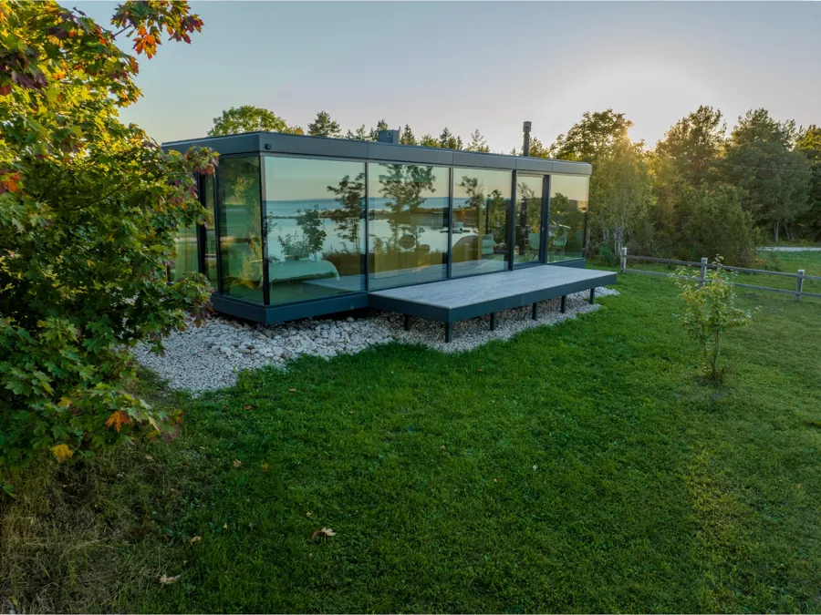Signature glass house seen from above among trees