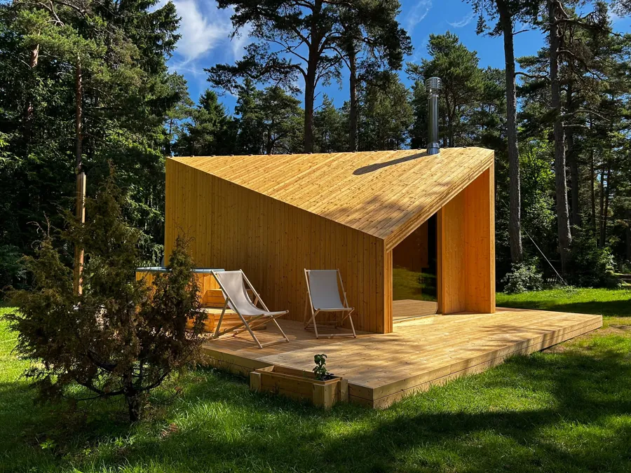 Zen timber cabin under pines with two deck chairs